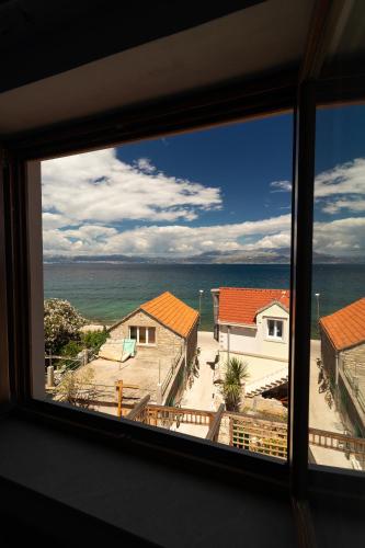 a view of the ocean from a window at Taverna & Rooms in Sutivan