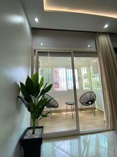 a room with chairs and a potted plant at Lovely 2 bedroom apartment in Rabat