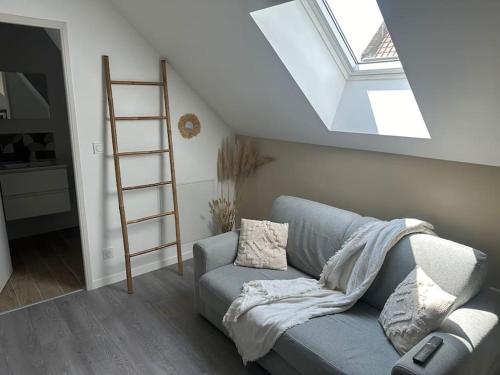 - un salon avec un canapé bleu et une lucarne dans l'établissement Oslo 2 personnes, à Amiens