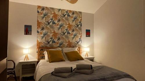 een slaapkamer met een groot bed met 2 lampen bij Voyage à Cocoa Beach in Bouguenais