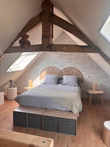 - une chambre mansardée avec un grand lit dans l'établissement Le Cottage d'Emmy - Rose, à Commes