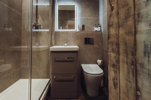 a bathroom with a toilet and a sink and a shower at South Causey Inn in Stanley
