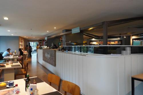 a restaurant with people sitting at tables and a bar at LANDSCAPE SOLAR - Beira Mar de Fortaleza in Fortaleza