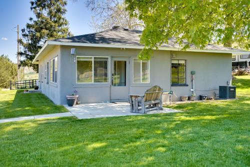 a small white house with a bench in the yard at Charming Emmett Home with Patio - 14 Mi to Reservoir in Emmett
