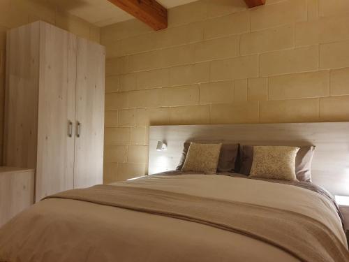 een slaapkamer met een groot bed met 2 kussens bij Id-Dwejra, Country Residence in Misraħ Suffara