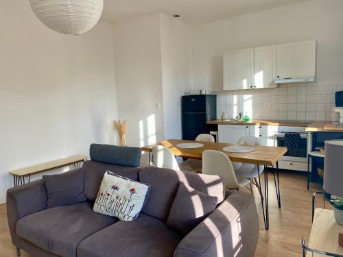 un salon avec un canapé et une cuisine dans l'établissement Charmant T2 de 48m2 à 300m du centre ville, à Lézignan-Corbières