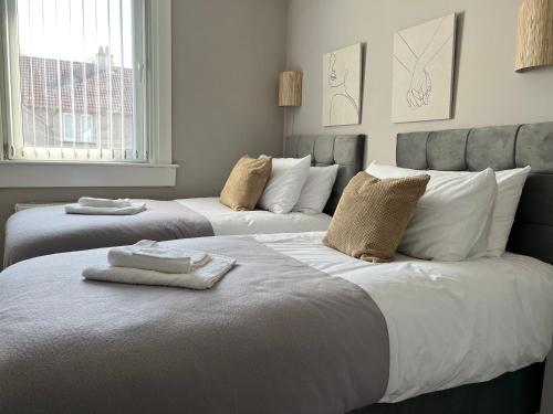 a bedroom with two beds with towels on them at Spacious Luxury 3 Bedroom Flat in Kirkcaldy, Fife in Fife