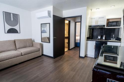 a living room with a couch and a kitchen at Sands Inn & Suites in San Luis Obispo
