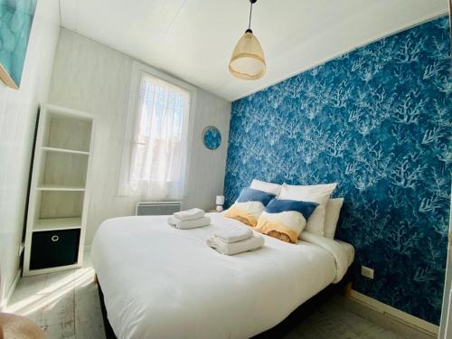 a bedroom with a large white bed with blue walls at Chez Sophie in Le Crotoy