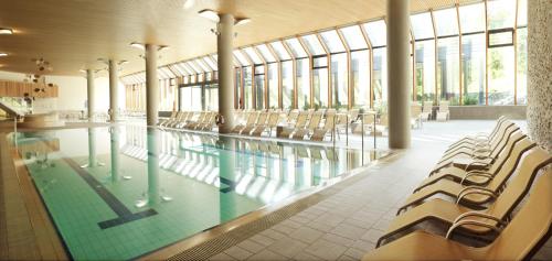 a swimming pool with chairs in a building at Špik Alpine Resort in Kranjska Gora