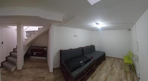 a living room with a couch and a staircase at Casa Palermo Manizales in Manizales