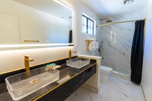W łazience znajduje się umywalka, toaleta i lustro. w obiekcie Sands Inn & Suites w mieście San Luis Obispo