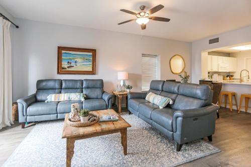 a living room with two couches and a table at Waterside Village Condo 304 - Coastal Joy by Pristine Properties Vacation Rentals in Mexico Beach