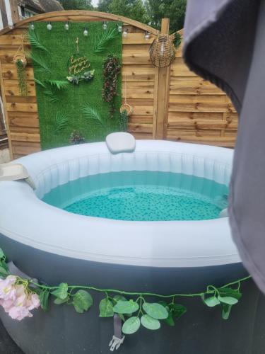 a hot tub in a backyard with a garden at Gite avec jacuzzi privé in Arnières-sur-Iton