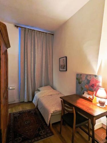 une petite chambre avec un lit et un bureau dans l'établissement Appart Authentique et confortable - Marais, à Paris
