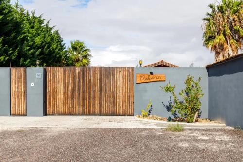 un garage avec une porte en bois et une clôture dans l'établissement Chalé do Vale, à Pinhal Novo