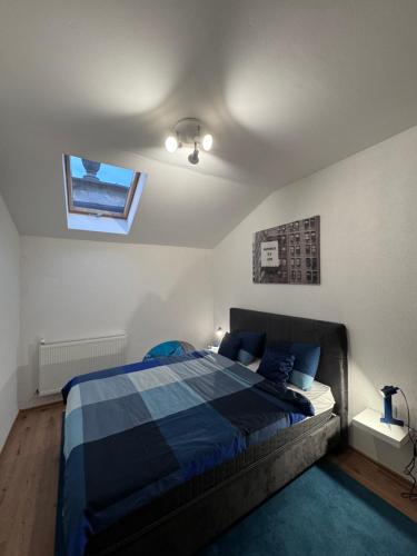 a bedroom with a bed with a blue comforter and a window at City centar Travnik in Travnik