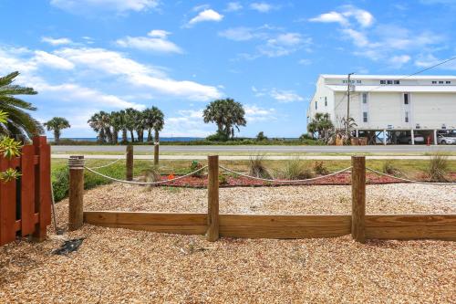 Saint Joe BeachにあるAlpha Blu by Pristine Properties Vacation Rentalsの建物の前にあるハンモック付きの木製のフェンス