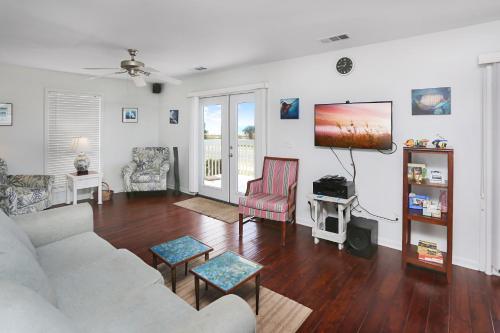 a living room with a couch and a tv at Alpha Blu by Pristine Properties Vacation Rentals in Saint Joe Beach