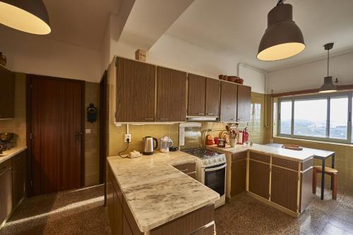 a kitchen with wooden cabinets and a counter top at Coimbra Heights in Coimbra