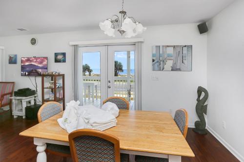 a dining room with a wooden table and chairs at Alpha Blu by Pristine Properties Vacation Rentals in Saint Joe Beach