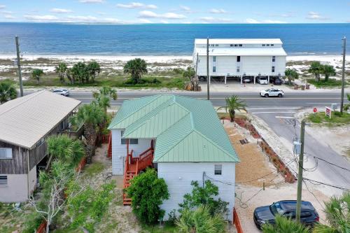 a house with a green roof in front of the ocean at Alpha Blu by Pristine Properties Vacation Rentals in Saint Joe Beach