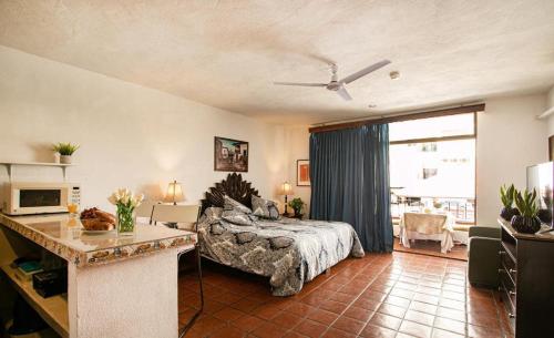 1 dormitorio con 1 cama y 1 mesa en una habitación en Vallarta Jr Suites en Puerto Vallarta