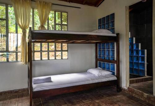 two bunk beds in a room with windows at Finca el Triunfo in Melgar