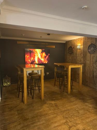 a room with two tables and a fire in the wall at The Harbour Bar & Bistro in Cemaes Bay