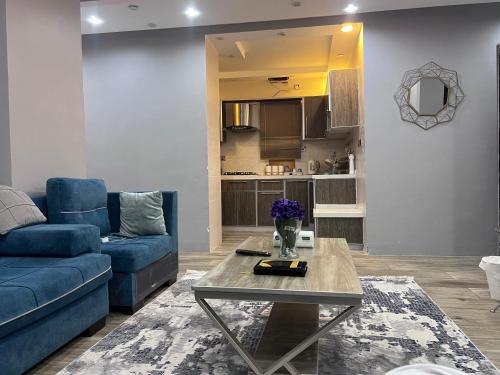 - un salon avec un canapé bleu et une table dans l'établissement شقة نصف القمر, à La Mecque