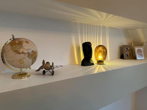 une étagère avec un globe et une lampe dessus dans l'établissement Victoria 2 personnes, à Amiens