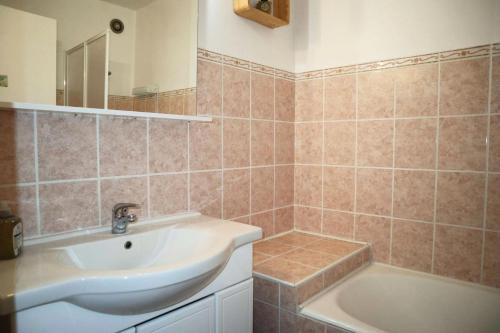 une salle de bain avec un lavabo et une baignoire dans l'établissement Résidence Le Sunny Snow - Résidence Le Sunny Snow à deux pas du centre de la station MAE-8144, aux Orres