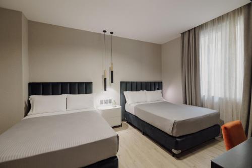 a hotel room with two beds and a window at Grand Brizo Bel Air in Buenos Aires