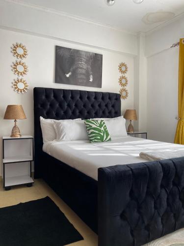 sypialnia z dużym łóżkiem z czarnym zagłówkiem w obiekcie New Haven 3 w mieście Kisii