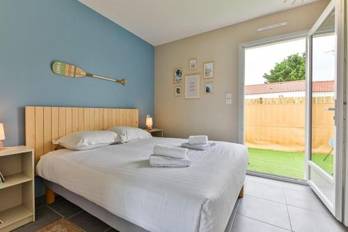 een slaapkamer met een groot bed en een groot raam bij Serpentine, à 5mn des plages in Saint-Hilaire-de-Riez