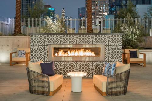 a patio with two chairs and a fireplace at Sky-Rise Apartments in Los Angeles