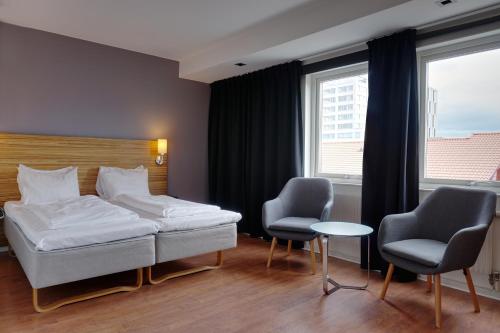 Comfort Hotel Jönköping في يونيشوبينغ: غرفة نوم بسرير وكرسيين وطاولة
