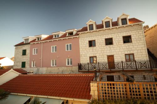 a large brick building with a balcony on top of roofs at Taverna & Rooms in Sutivan