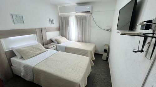 um quarto de hotel com duas camas e uma televisão de ecrã plano em Hotel Plaza Formosa em Formosa