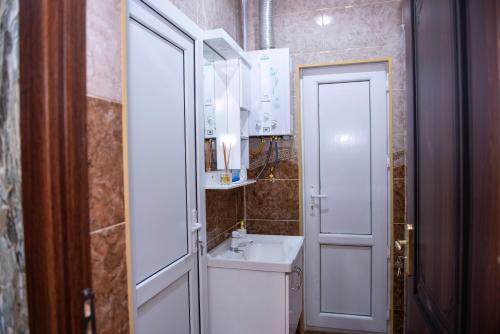 a bathroom with a white sink and a mirror at Harmony Haven House in Sheki