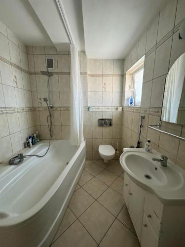 a bathroom with a tub and a sink and a toilet at Wileńska Pokoje in Słupsk