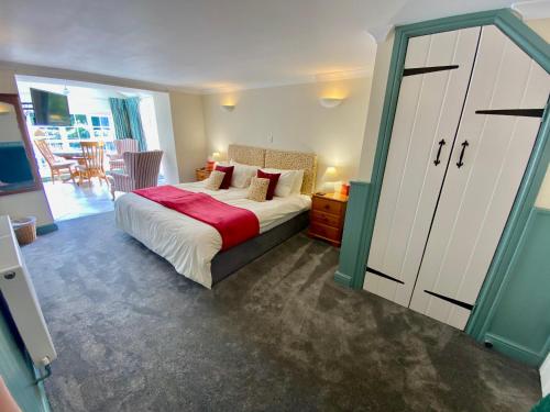 a bedroom with a bed with a red blanket at Lynwood House Self Contained Studio in Tregoney