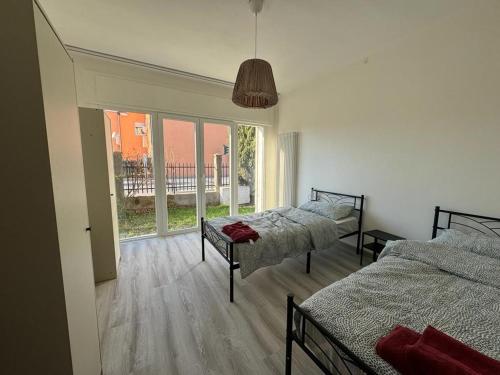 1 dormitorio con 2 camas y ventana grande en Lavanda House, en Vicenza