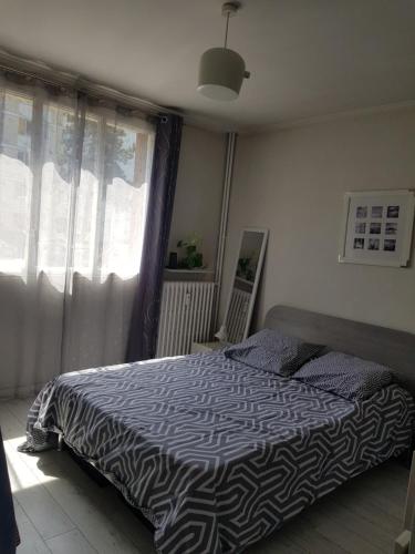 une chambre avec un lit avec une couette noire et blanche dans l'établissement Appartement près du lac d'Enghien les bains, à Enghien-les-Bains