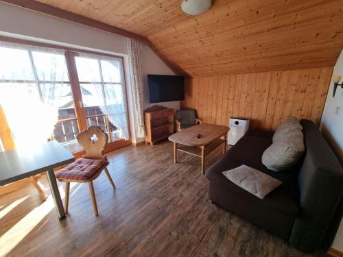 a living room with a couch and a table at am Buchbrunnen Comfortable holiday residence in Pfronten