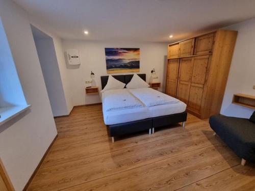 a bedroom with a bed and a couch in it at am Buchbrunnen Comfortable holiday residence in Pfronten