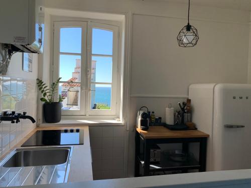 a kitchen with a sink and a window at Villa Anvers Guethary in Bidart