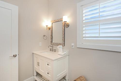 a white bathroom with a sink and a mirror at Second Chance by Pristine Properties Vacation Rentals in Mexico Beach