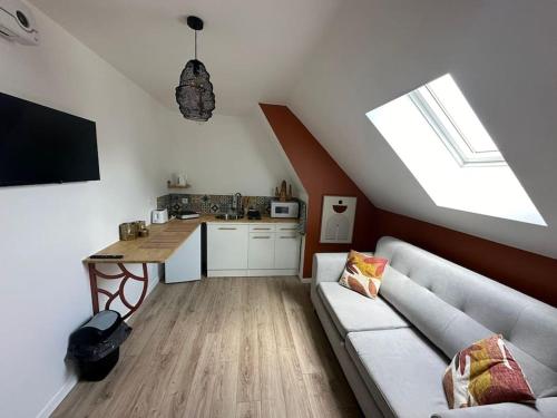 un salon avec un canapé et une cuisine dans l'établissement Zenata 2 personnes, à Amiens