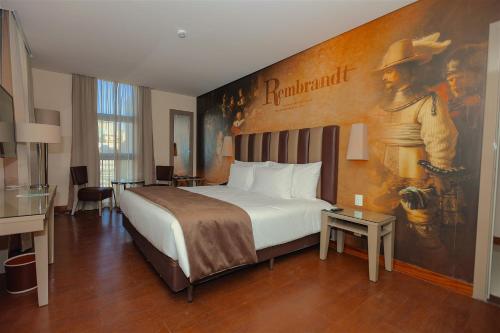 a hotel room with a bed with a painting on the wall at Vila Gal&eacute; Paulista in Sao Paulo